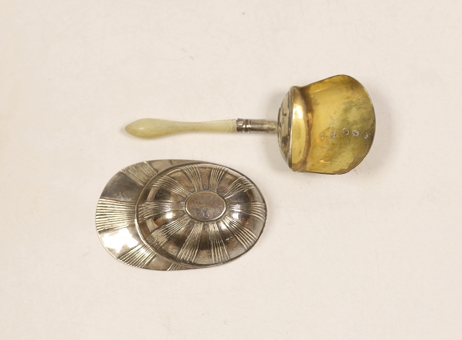 A George III silver jockey cap caddy spoon, Birmingham, 1798?, 54mm and another George III silver gilt shovel caddy spoon, with mother of pearl handle, Birmingham, 1806.